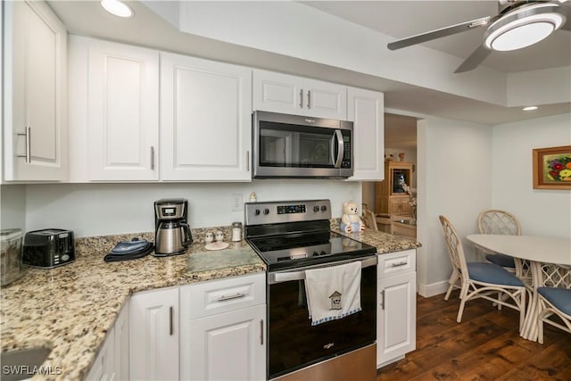 kitchen with stainless steel appliances, dark wood finished floors, white cabinetry, and a ceiling fan