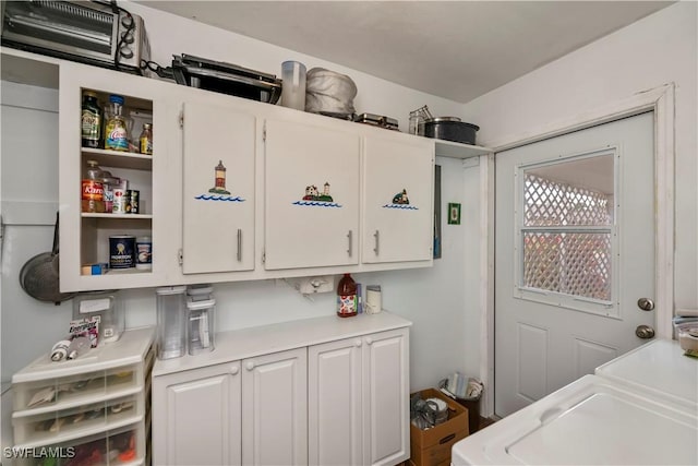 washroom featuring washer / dryer and cabinet space