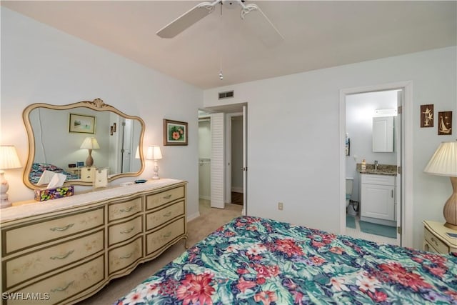 bedroom with light colored carpet, visible vents, connected bathroom, a sink, and ceiling fan