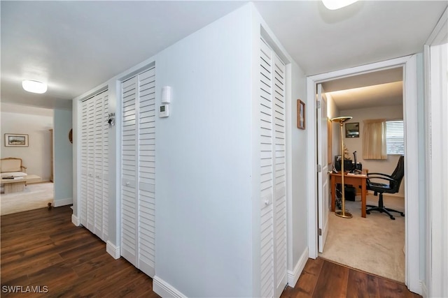 hallway featuring dark wood-style floors and baseboards