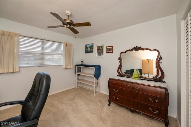 office with a ceiling fan, light carpet, and baseboards