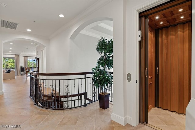 hallway with arched walkways, crown molding, recessed lighting, visible vents, and baseboards