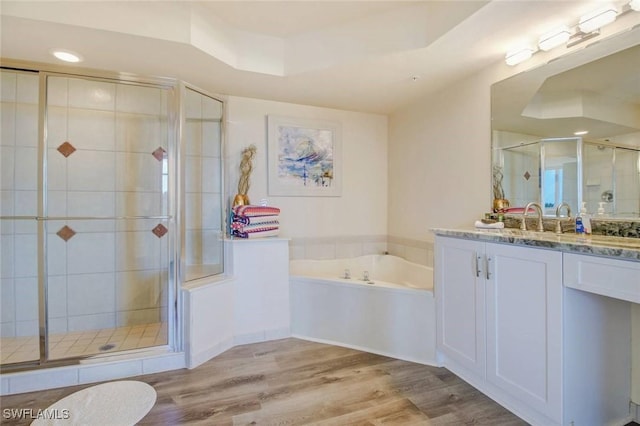 full bath with a garden tub, wood finished floors, vanity, and a shower stall