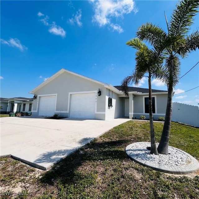 ranch-style house featuring concrete driveway, fence, an attached garage, and stucco siding