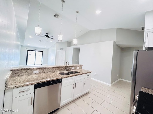 kitchen featuring stainless steel appliances, lofted ceiling, white cabinetry, a sink, and light stone countertops