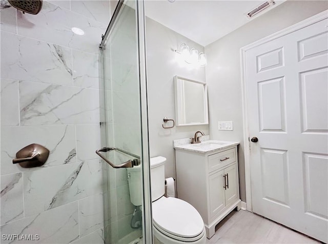 bathroom with toilet, a stall shower, visible vents, and vanity