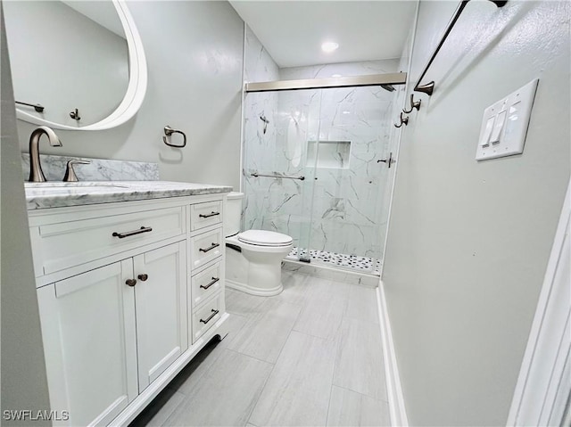 full bathroom featuring toilet, vanity, and a marble finish shower