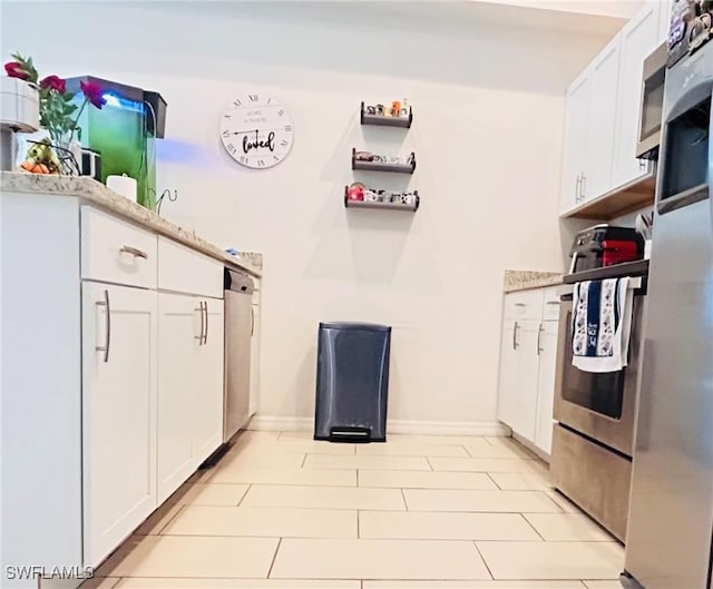 kitchen featuring baseboards and white cabinets