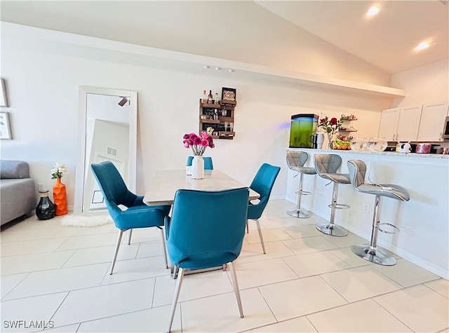 dining room featuring tile patterned flooring, vaulted ceiling, and recessed lighting