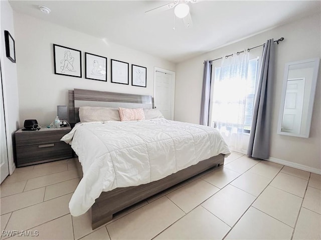 bedroom featuring ceiling fan, baseboards, and light tile patterned flooring