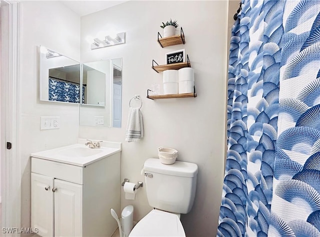 bathroom featuring curtained shower, vanity, and toilet