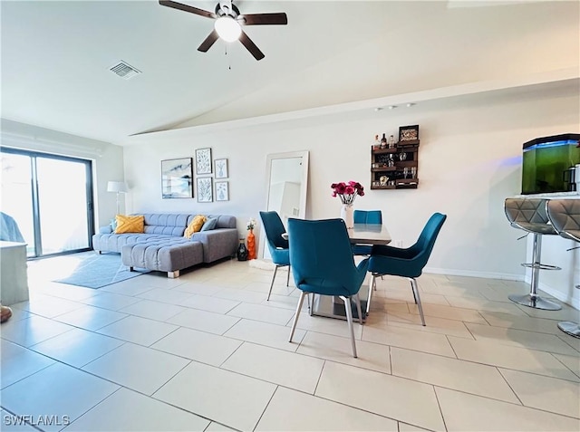 tiled dining room with lofted ceiling, baseboards, visible vents, and a ceiling fan