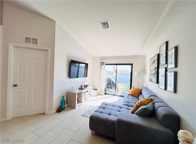 living area featuring vaulted ceiling, visible vents, and baseboards