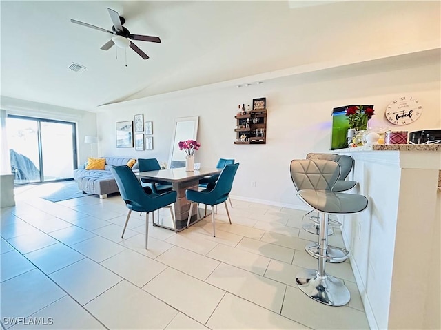 dining room with light tile patterned floors, baseboards, visible vents, a ceiling fan, and lofted ceiling