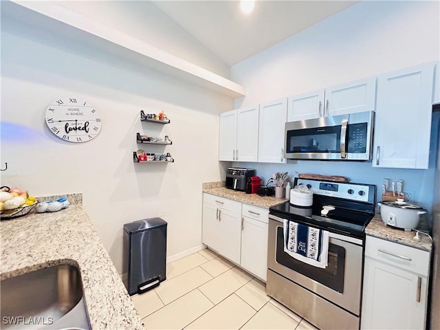 kitchen featuring stainless steel appliances, light tile patterned flooring, white cabinetry, and light stone countertops