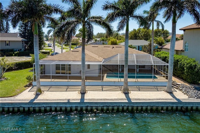 rear view of house featuring a lanai, a patio area, and an outdoor pool