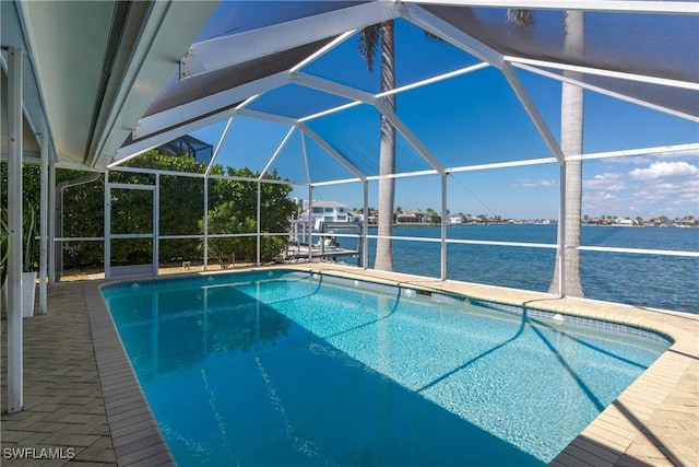 outdoor pool featuring a lanai, a water view, and a patio