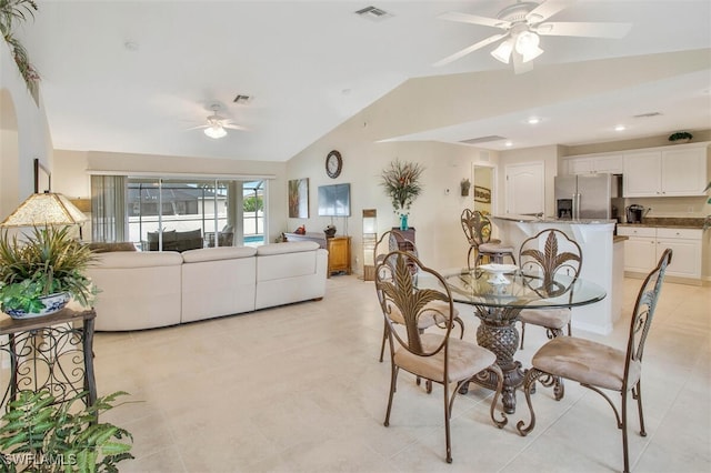 dining room with ceiling fan, visible vents, vaulted ceiling, and light tile patterned flooring