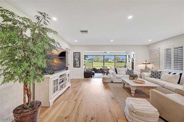 living area with light wood-style floors, recessed lighting, and visible vents