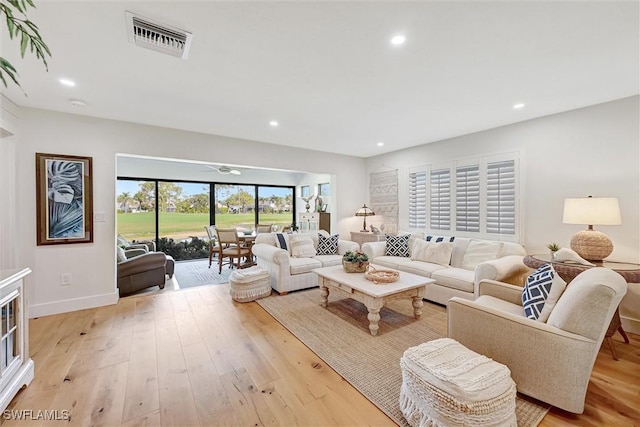 living room featuring light wood-style floors, recessed lighting, visible vents, and baseboards