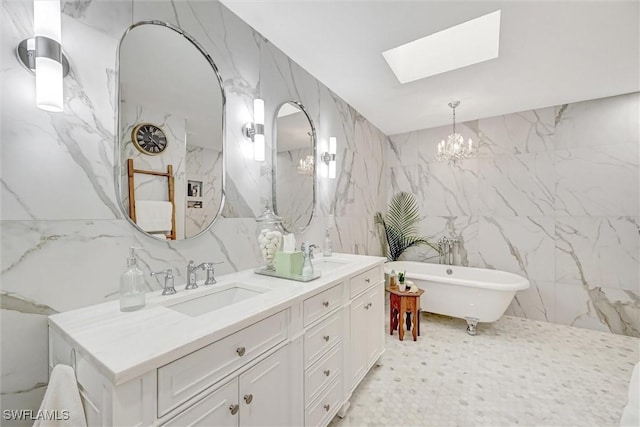 bathroom with a skylight, tile walls, a soaking tub, a sink, and stone wall