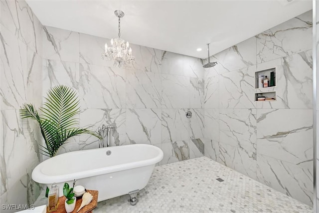 full bath with a soaking tub, stone wall, and a chandelier