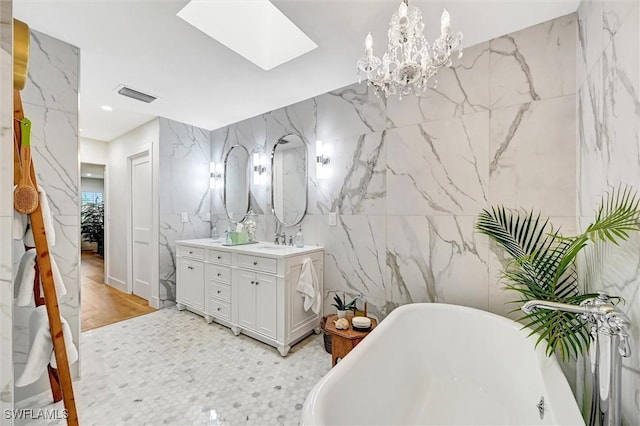 bathroom featuring stone wall, a sink, visible vents, a soaking tub, and double vanity