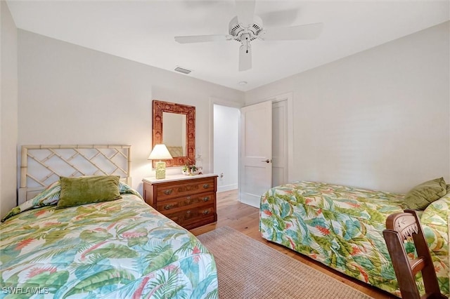 bedroom with visible vents, light wood-style flooring, and a ceiling fan