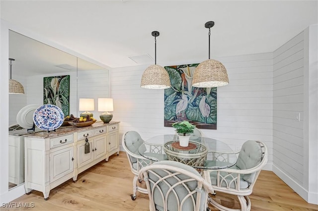 dining space featuring baseboards and light wood finished floors