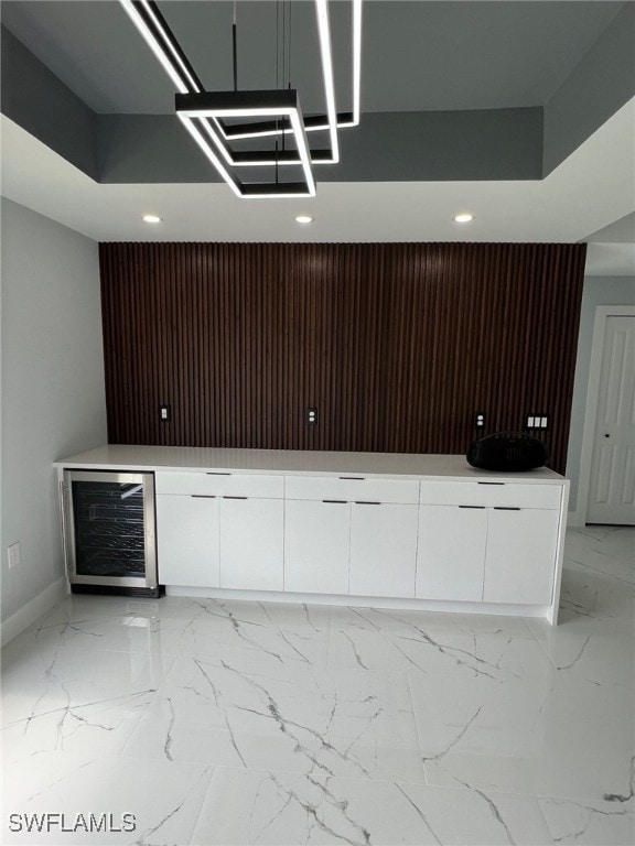 bar with marble finish floor, wine cooler, baseboards, and recessed lighting