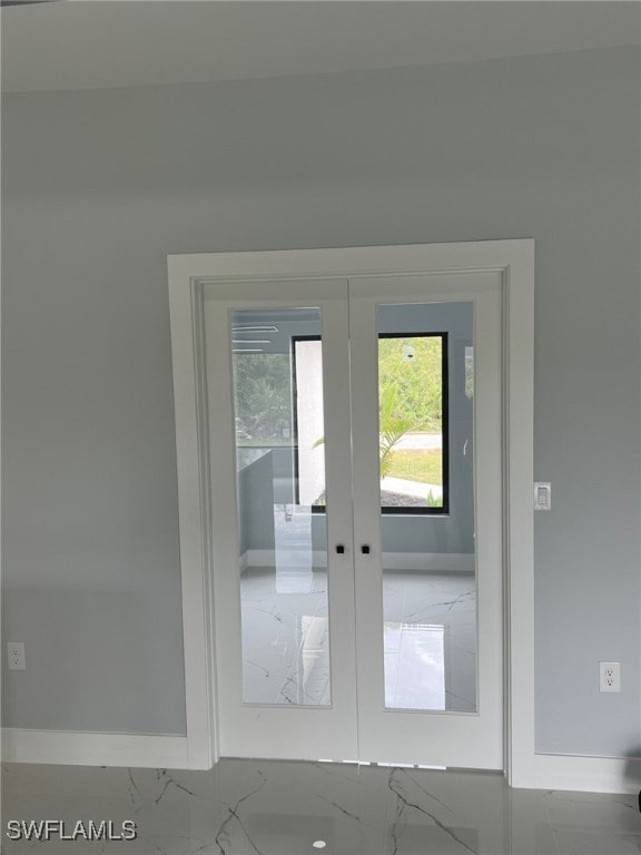 doorway featuring a healthy amount of sunlight, marble finish floor, and french doors