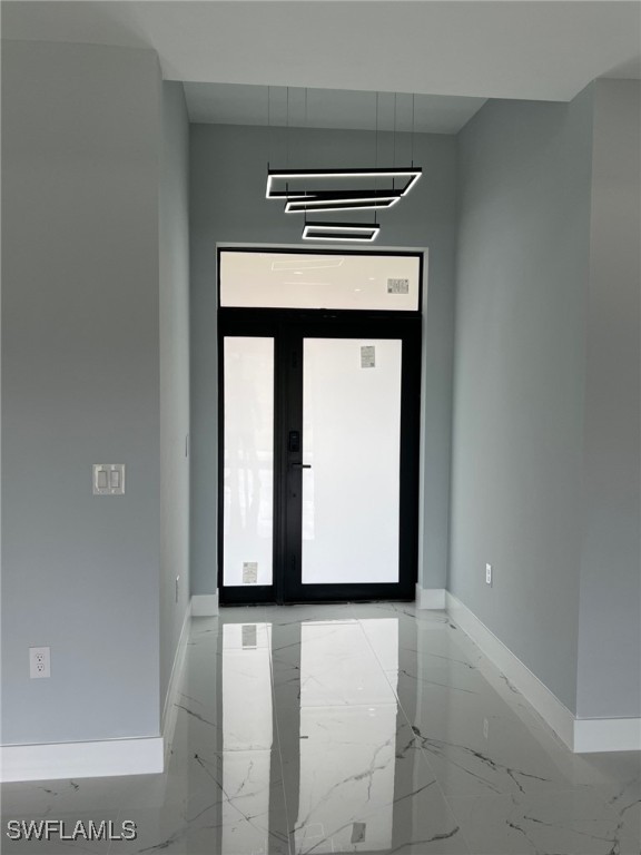 empty room featuring marble finish floor and baseboards