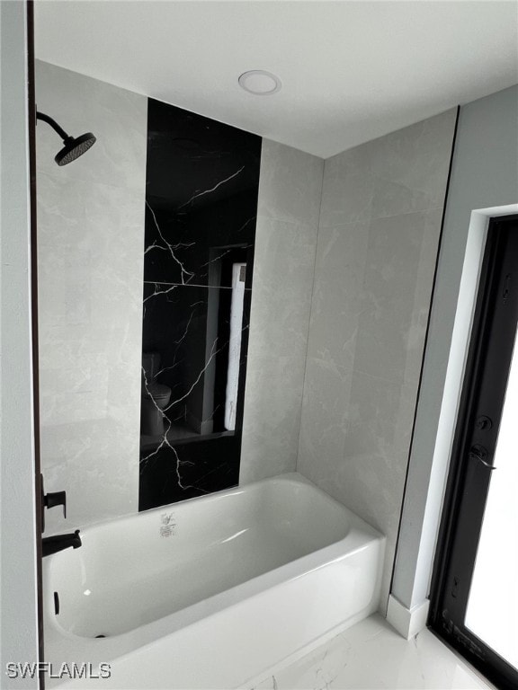 bathroom featuring marble finish floor and shower / bathing tub combination