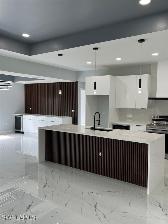 kitchen featuring electric stove, modern cabinets, decorative light fixtures, light countertops, and a sink