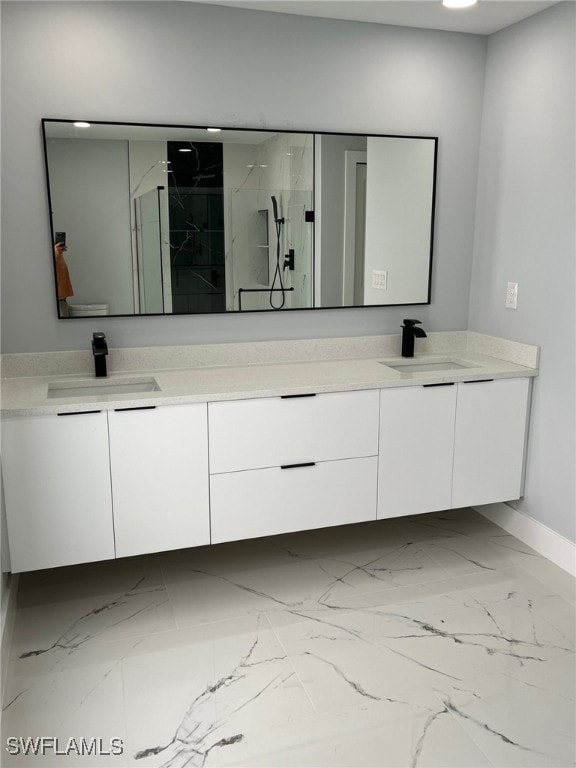 full bath with double vanity, marble finish floor, a marble finish shower, and a sink