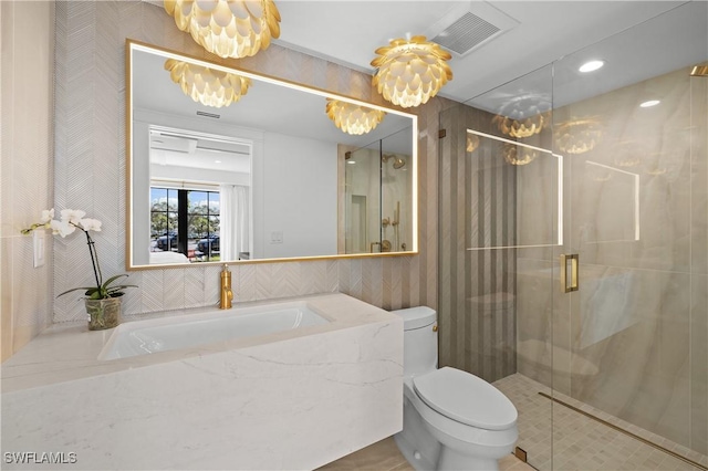 full bathroom with toilet, a sink, a shower stall, and visible vents