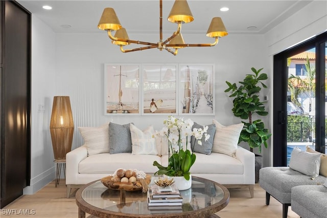 living room featuring light wood-style flooring, a notable chandelier, and recessed lighting