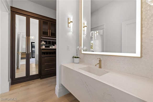 bathroom with french doors, wood finished floors, and vanity