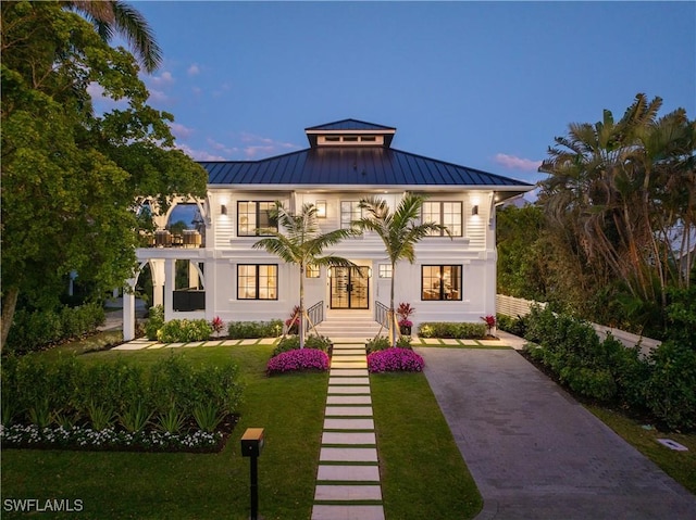 view of front of property with a standing seam roof, metal roof, french doors, and a front yard