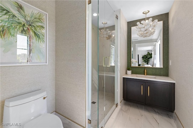 bathroom with marble finish floor, toilet, a stall shower, vanity, and a chandelier