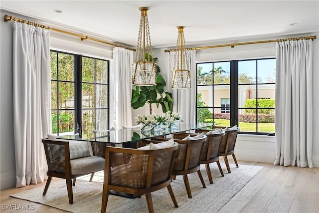 dining area with hardwood / wood-style floors and crown molding