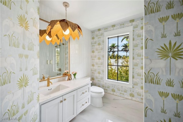 bathroom featuring marble finish floor, vanity, toilet, and wallpapered walls