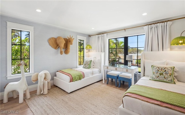 bedroom with recessed lighting, multiple windows, baseboards, and wood finished floors