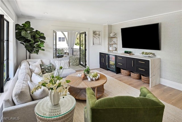 living room featuring light wood-type flooring, baseboards, and wine cooler