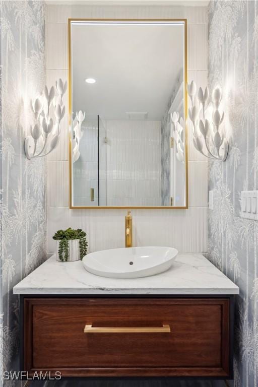 bathroom with vanity and wallpapered walls