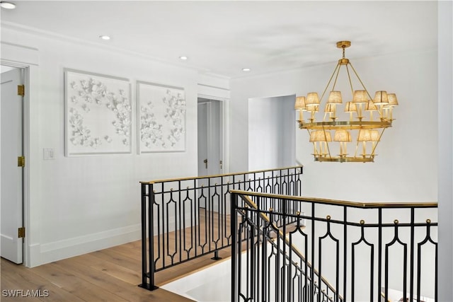 hall with recessed lighting, a notable chandelier, wood finished floors, an upstairs landing, and baseboards