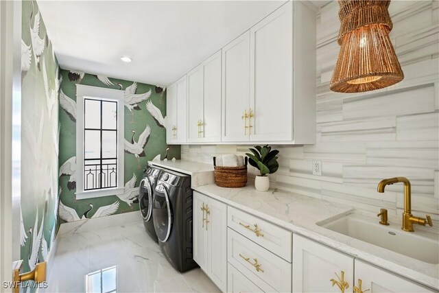 clothes washing area featuring independent washer and dryer, a sink, cabinet space, and recessed lighting