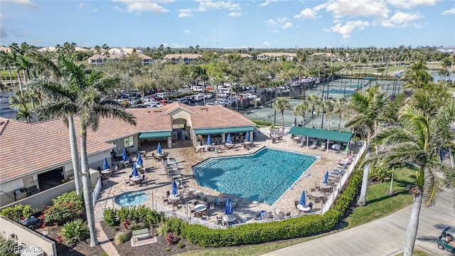 community pool with a patio area and fence