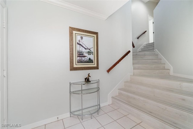 stairs with tile patterned flooring, ornamental molding, and baseboards