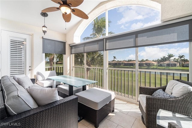 sunroom / solarium featuring ceiling fan, a water view, and lofted ceiling